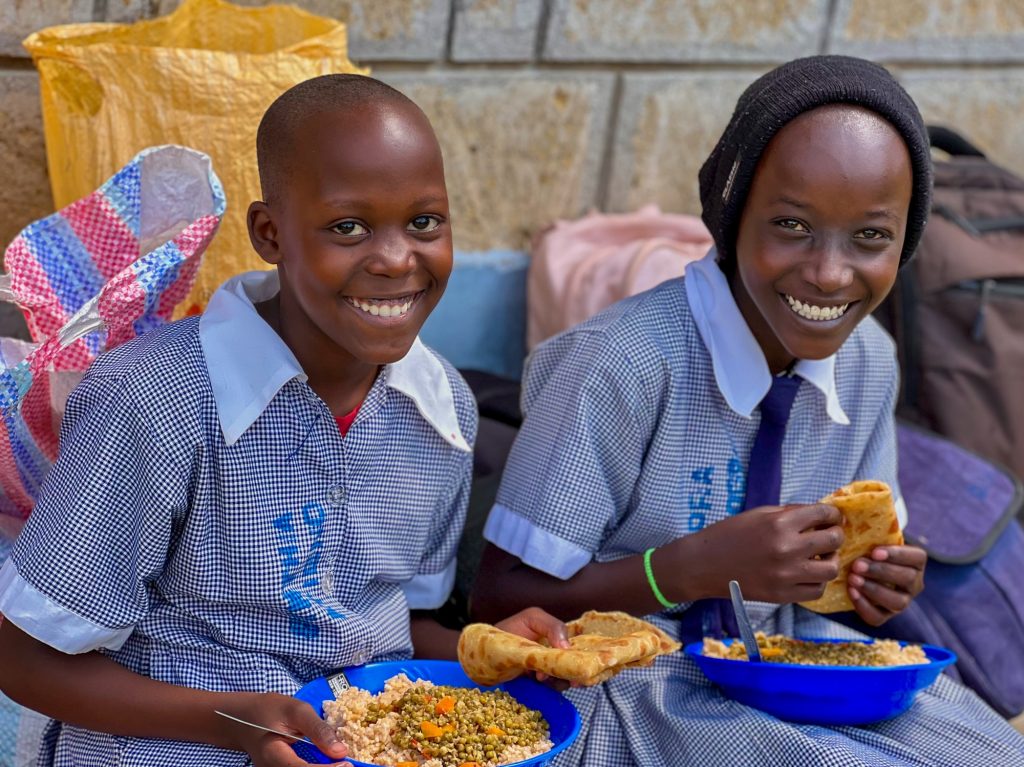 Two scholars eating and smiling